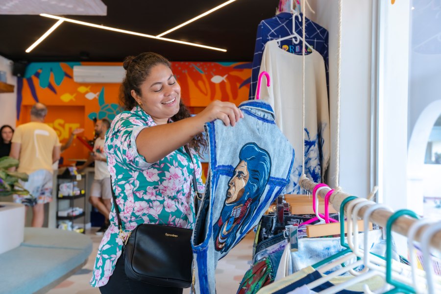 Mujer sonriente eligiendo una chaqueta dentro del showroom de Casa Marina.